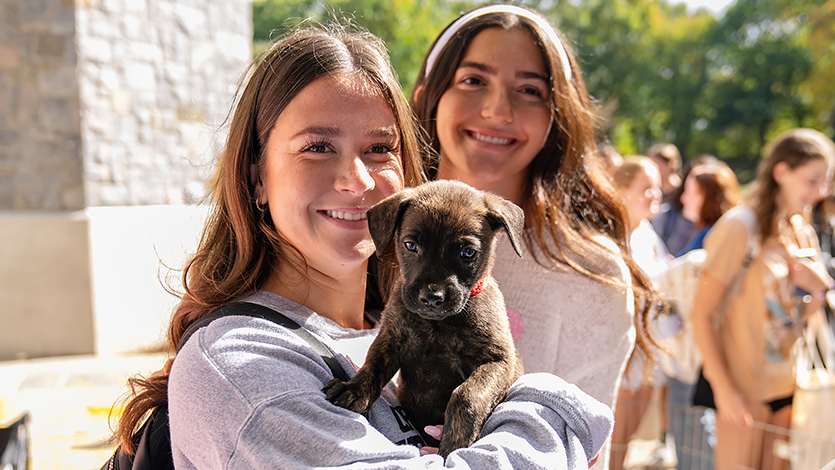 Image of student holding a puppy.