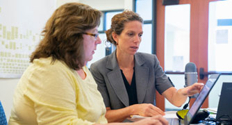 Image of a faculty member and digital education team member collaborating.