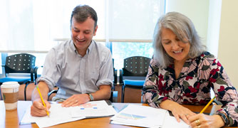 Image of two faculty members reviewing documents.