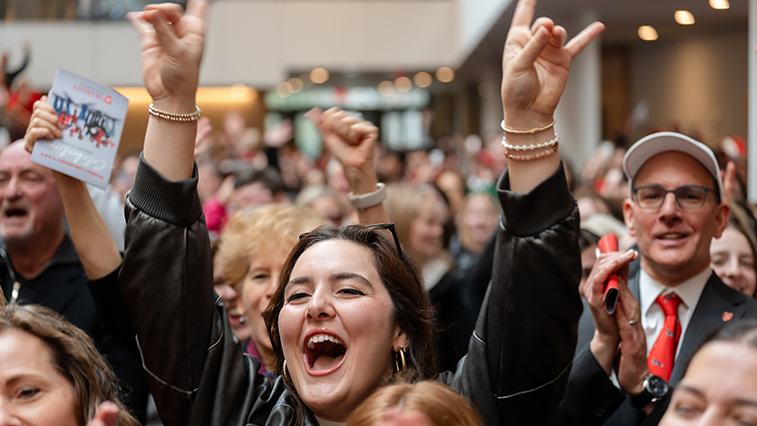 Image of attendees in the Dyson Center cheering as Marist officially becomes a University.