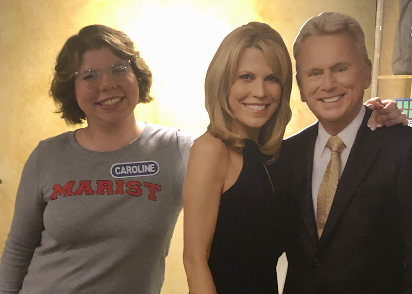 Photo of Caroline Fiske with cardboard cutouts of Pat Sajak and Vanna White