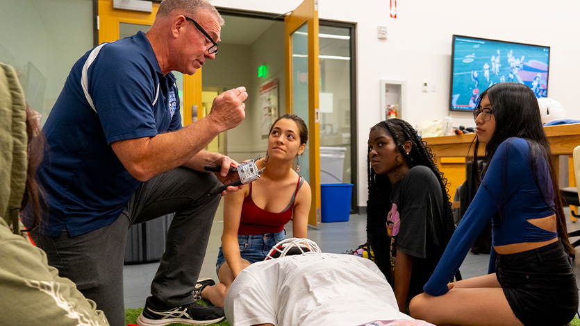 Image of students learning about athletic emergency health procedures during a Pre-Health class at Summer Pre-College. 
