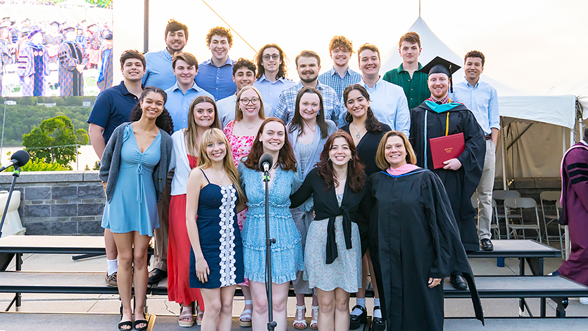 Image of Sarah and group of students at Commencement. 