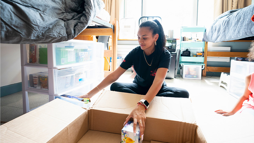 Image of student unpacking in dorm room.