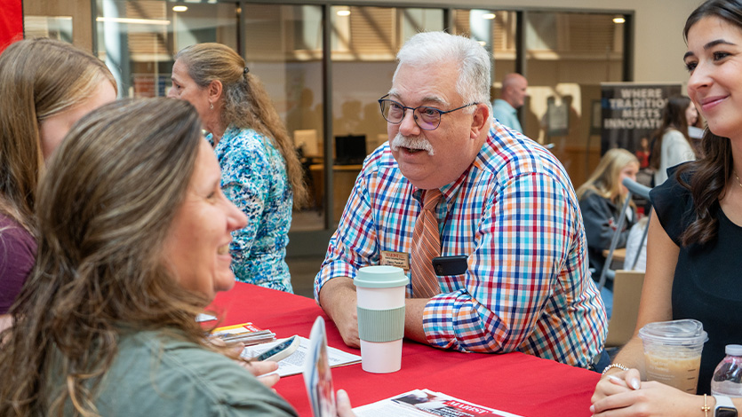 Image of faculty members meeting with attendees.