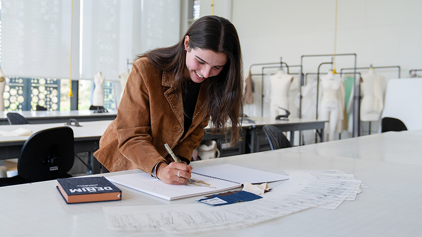 Image of Lena Alibrio '26 working on her denim designs in the Steel Plant. Photo by Nelson Echeverria/Marist University.