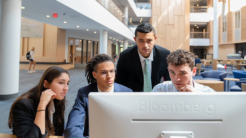 Students working at Bloomberg Terminals in the Dyson Center atrium.