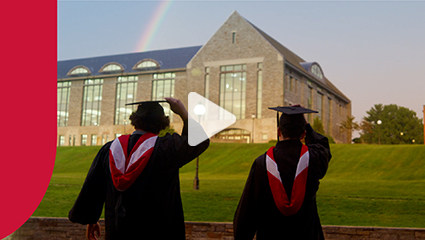 Image of students throwing graduation caps with a rainbow over the library.