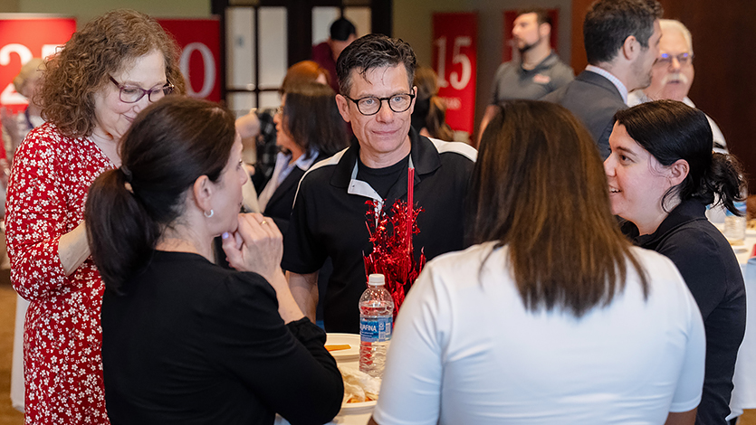 Image of Milestone honoree Colin McCann, Associate Director of First-Year Experience, networks with his Student Affairs peers during the event. 