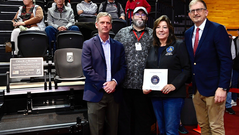 image of: The Chair of Honor unveiling at McCann Arena (Standing, from L-R: President Kevin Weinman, Associate Professor Tommy Zurhellen, Senator Sue Serino, Executive Vice President Geoffrey Brackett). Photo courtesy of Marist College Athletics