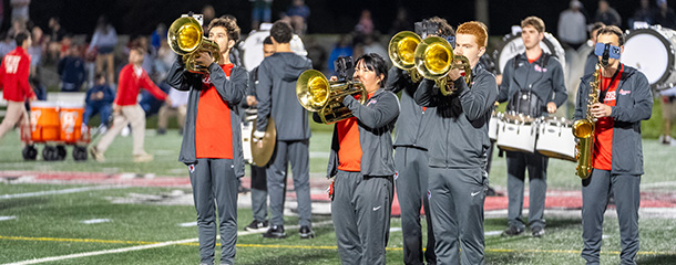 Marist University image: the Marist marching band plays on the football field at halftime.
