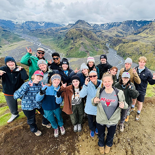 Marist University image: Students pose with Icelandic mountain terrain in background.