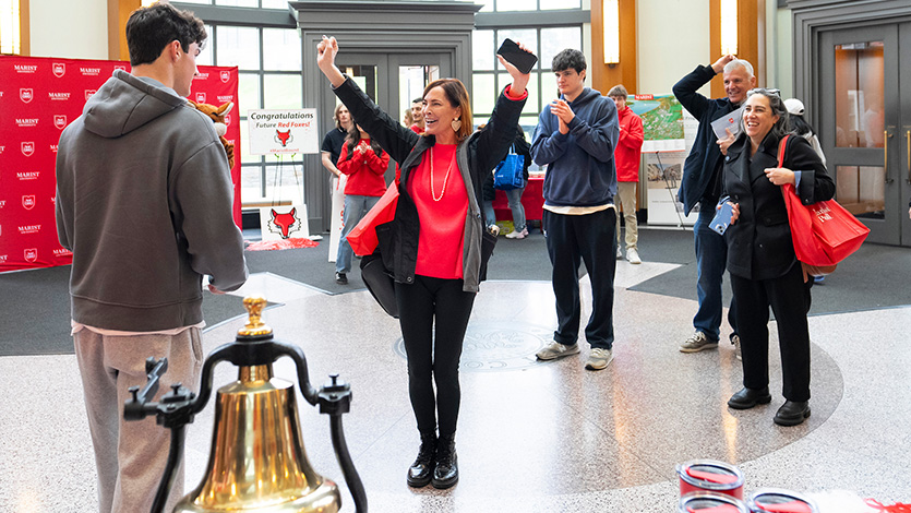 Image of a student ringing the bell in the Student Center Rotunda at Admitted Students Day 2025 at Marist University.