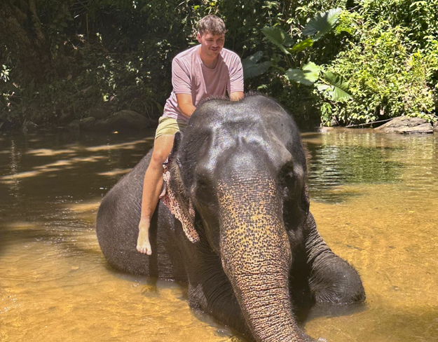 Image of Jacob Richard riding an elephant.