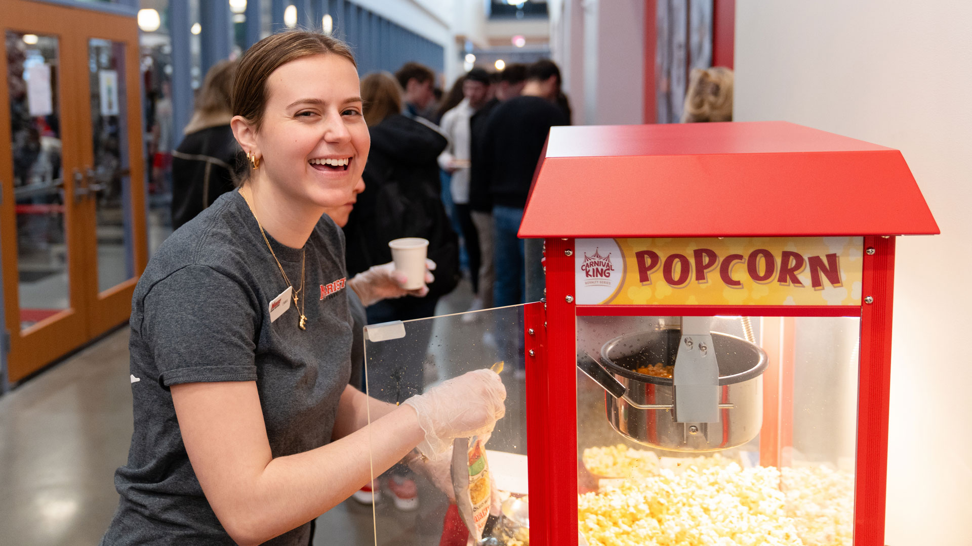 Image of a student getting popcorn at the Marist University Day community block party.