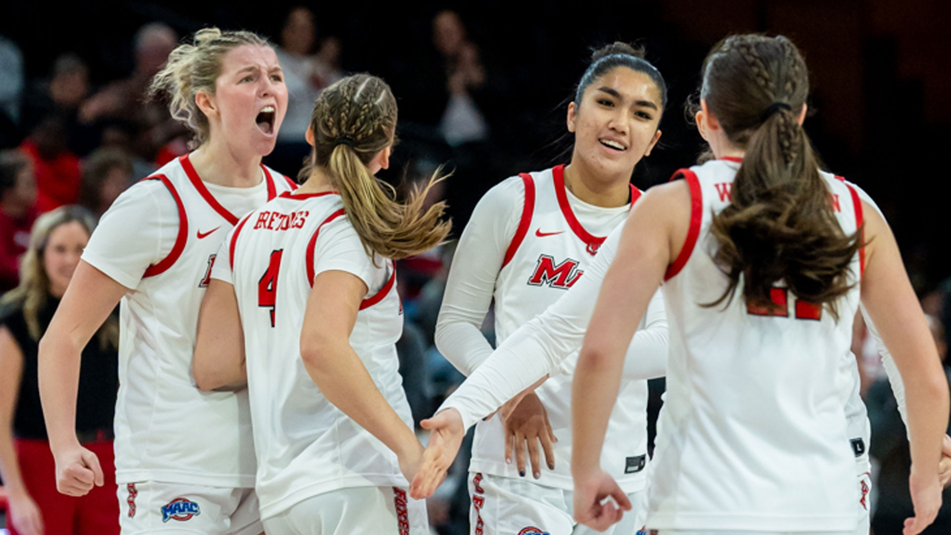 Image of the Marist University women's basketball team celebrating a victory.