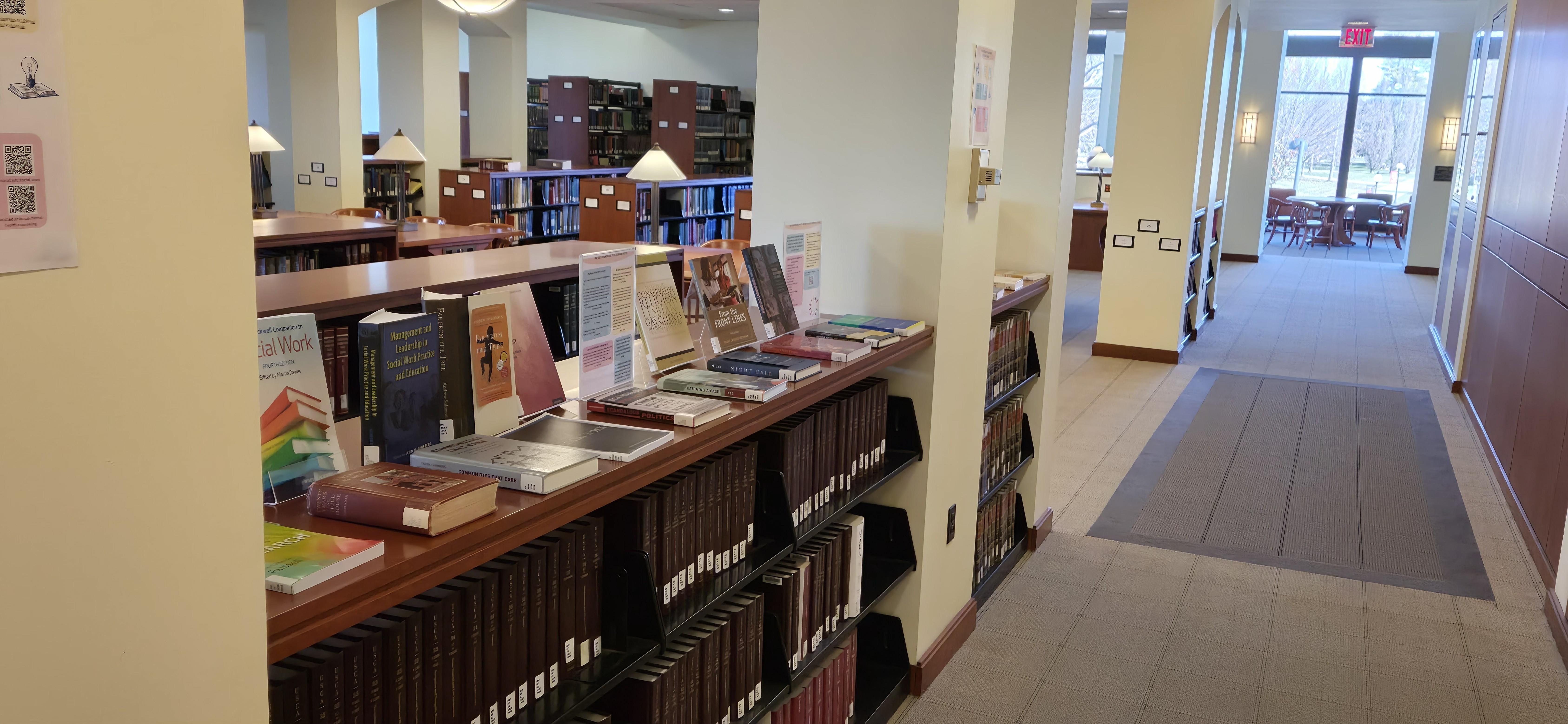 	  Library books on social work set up on display. Book titles include "Far From the Tree" and "Management and Leadership in Social Work Practice and Education."