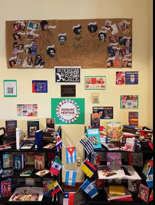 A library display honoring Hispanig Heritage Month. Contents include carts of books, flags, and a poster and infographics adhered to the wall. 